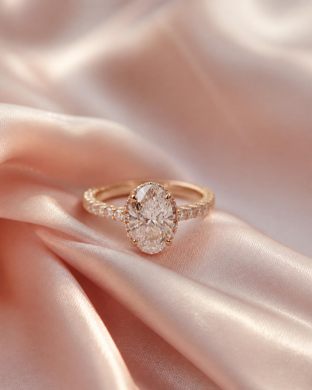 Oval diamond engagement ring on blush silk